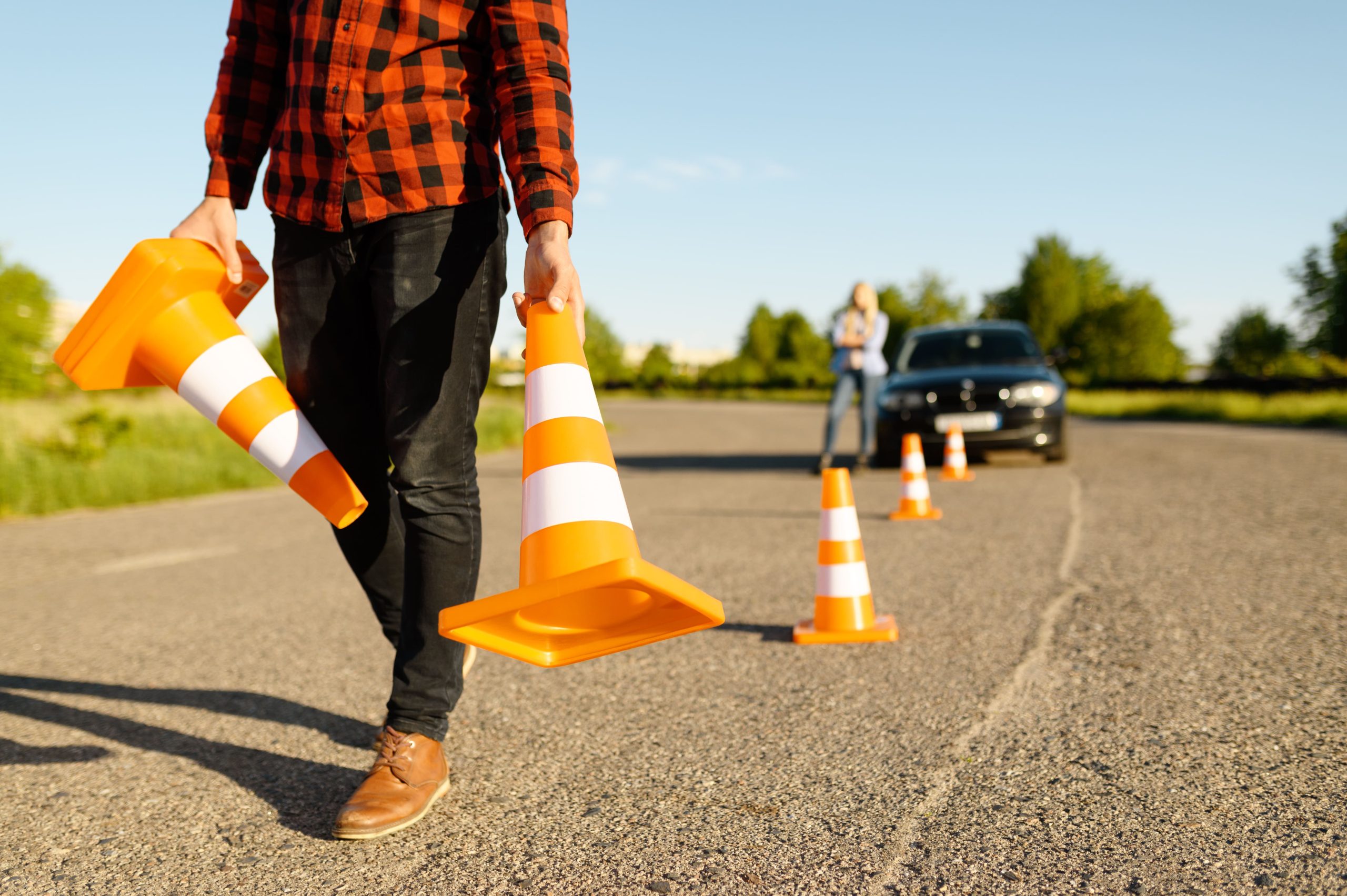 male-instructor-puts-cones-on-road-driving-school-2023-11-27-05-00-12-utc-1